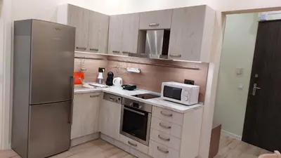 a kitchen with a stainless steel refrigerator and a microwave at Апартамент Pink & Blue - 2BDR with Balcony - Wi-Fi in Varna City