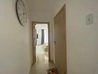 a hallway with a clock on the wall and a room at VILLA ITTA 05 Apartment Sunny Beach in Sunny Beach