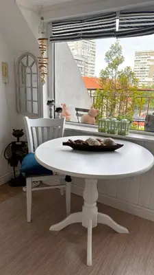 a white table and chairs in a room with a window at Studio San Stefano in Burgas City