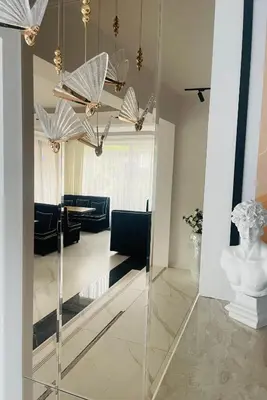 a room with a mirror and a living room with umbrellas at Hotel AVENUE in Ravda