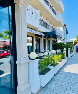 a building with a row of plants in front of it at Hotel AVENUE in Ravda
