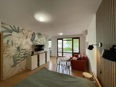 a living room with a bed and a tv and a couch at Messambria Fort Beach - Premium Apartments in Elenite