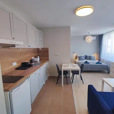 a kitchen and living room with a table and a couch at Holiday Fort Golf Club - Premium Apartments in Sunny Beach