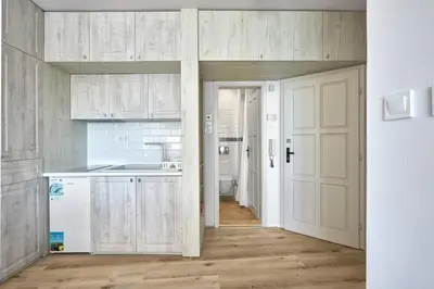 a kitchen with white cabinets and a sink and a door at 1BD Flat with a stunning SEA VIEW in Sozopol by Flаt Manаger in Sozopol