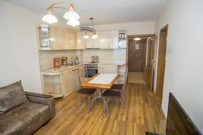 a kitchen and dining room with a table and a couch at Guest apartments STELA in Tsarevo
