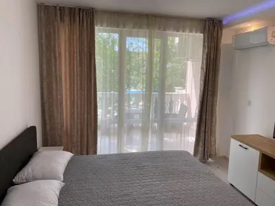 a bedroom with a bed and a large window at Студио Симона 3 - първа линия море in Lozenets