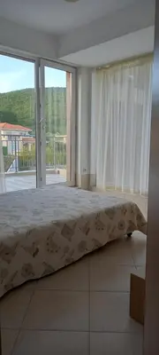 a bedroom with a bed and a large window at Апартамент в Комплексе Сансет Кошарица,Солнечный берег in Kosharitsa