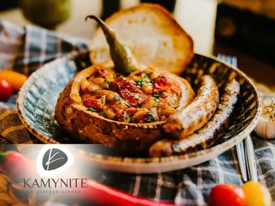 a plate of food with sausage and bread on a table at Хотел Камъните in Burgas City