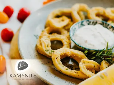 a plate of onion rings with a bowl of dipping sauce at Хотел Камъните in Burgas City