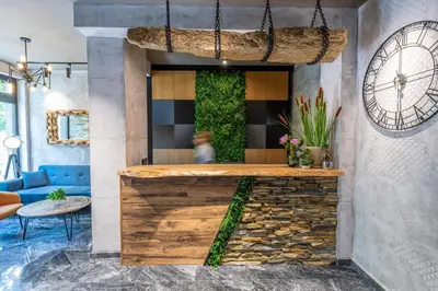 a lobby with a bar with a blue couch at Хотел Камъните in Burgas City