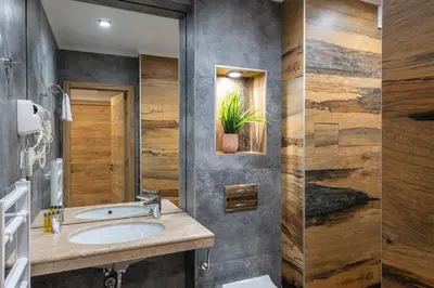 a bathroom with a sink and a potted plant at Хотел Камъните in Burgas City