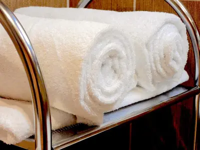 a stack of white towels on a metal rack at APARTELLO Premier Fort - Sea & Pool View - Sveti Vlas in Sunny Beach