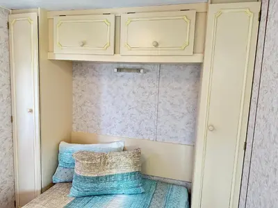 a small closet with yellow cabinets and blue pillows at Caravans 10 min to Tsonevo Lake & 35 min to Black Sea in Tsonevo
