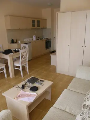 a living room with a table and a kitchen at Magic Dreams Apart Complex Studio Sveti Vlas in Sveti Vlas