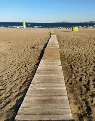 a wooden path through the sand on a beach at Top center apartment Gramophone with private parking in Burgas City