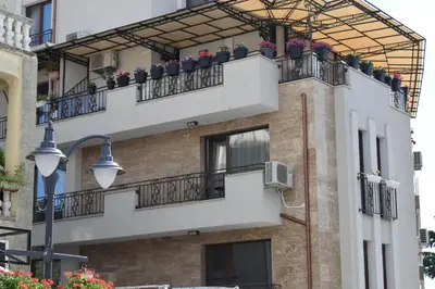 a building with balconies and potted plants on it at Top center apartment Gramophone with private parking in Burgas City