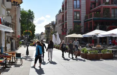 a group of people walking down a city street at Top center apartment Gramophone with private parking in Burgas City