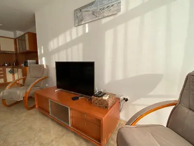 a living room with a flat screen tv on a wooden table at ANITA A15 Family Apartment Sunny Beach in Sunny Beach