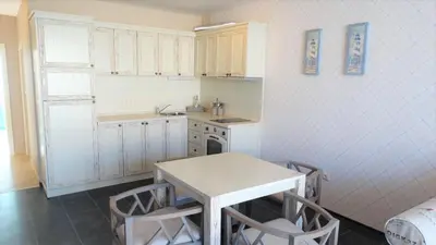 a small kitchen with a table and chairs in it at Captain's Island Deluxe in Chernomorets