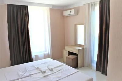 a bedroom with a white bed and a mirror at Private apartments Stamopolu lux in Primorsko