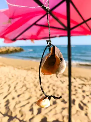 a stuffed animal hanging from a pink umbrella on the beach at William's apartments - second cozy studio in Sveti Vlas