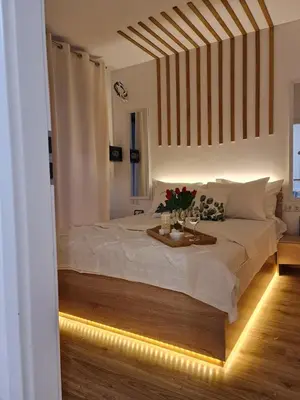 a bedroom with a large white bed with lights at Little Treasure by the Sea in Pomorie