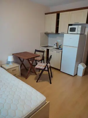 a small kitchen with a table and a white refrigerator at Prestige Fort Beach Private Apartment-Studio 46 in Sveti Vlas