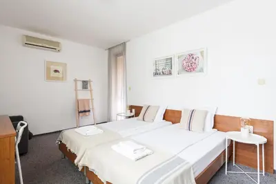 a hotel room with two beds and a table at Sea House Afrodita II in Nesebar