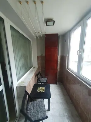 a room with two chairs and a bench and windows at Eli Apartment Burgas Center in Burgas City