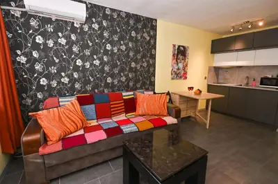 a living room with a couch and a kitchen at Eli Apartment Burgas Center in Burgas City