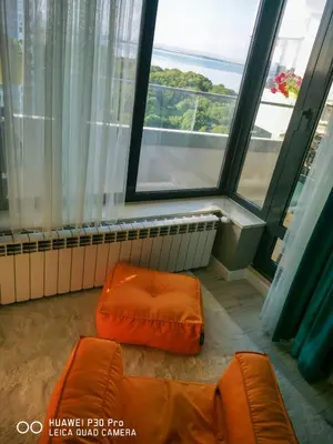 a living room with orange furniture and large windows at Luxury Apartments Alix in Burgas City