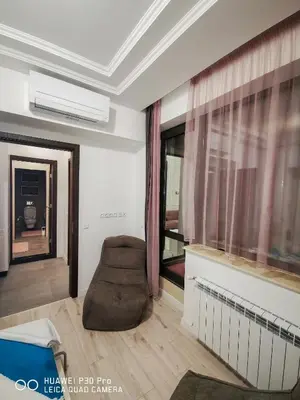 a living room with a chair and a window at Luxury Apartments Alix in Burgas City