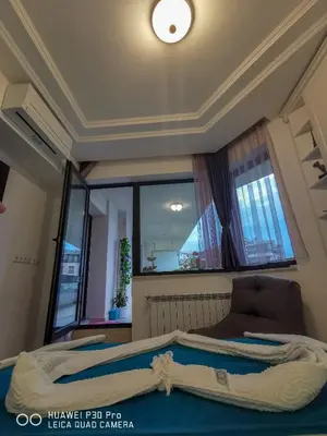 a bed in a room with a large window at Luxury Apartments Alix in Burgas City