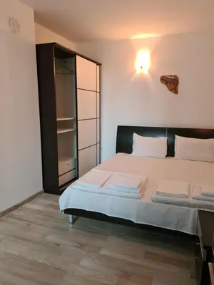 a bedroom with a large bed and a closet at Guest Rooms Kostovi in Nesebar
