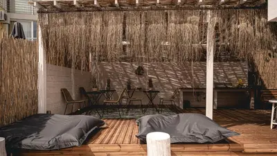 a patio with a table and chairs on a wooden deck at La Finca - Saint Vlas in Sveti Vlas
