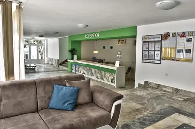 a living room with a couch and a kitchen at Hotel Forest Beach in Primorsko