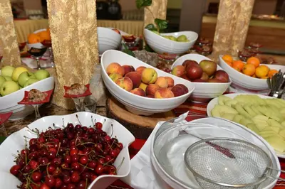 a table with bowls of apples and other fruits on it at Hotel Forest Beach in Primorsko