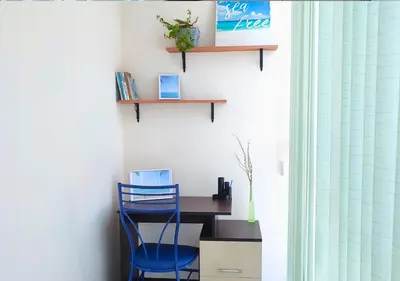 a blue chair sitting at a desk in a room at Апартамент FLAME in Sunny Beach
