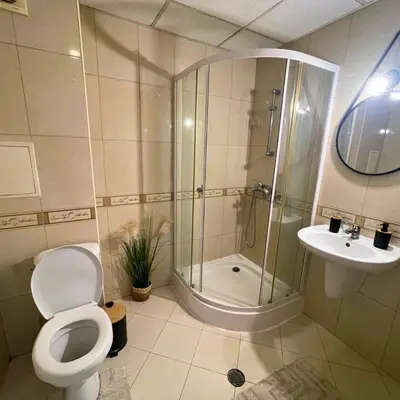 a bathroom with a shower and a toilet and a sink at Апартамент FLAME in Sunny Beach