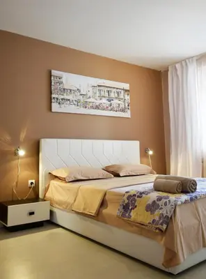 a bedroom with a large bed with a white headboard at dream apartment in Obzor