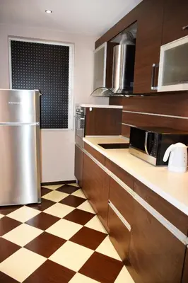 a kitchen with wooden cabinets and a checkered floor at dream apartment in Obzor