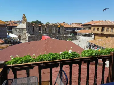 a balcony with a roof with plants on it at The Old House in Nesebar