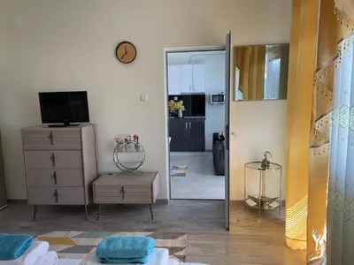 a living room with a dresser and a mirror at Къща за гости Синьо Лято in Pomorie