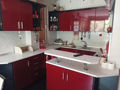 a kitchen with red cabinets and a sink at Къща за гости Синьо Лято in Pomorie