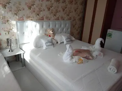 a bedroom with stuffed animals on a bed with a mirror at Къща за гости Синьо Лято in Pomorie