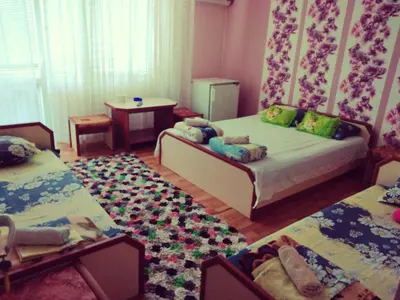 a bedroom with two beds and a rug at Къща за гости Синьо Лято in Pomorie