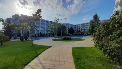 a large building with a walkway in a park at Decor in Atlantis Resort&SPA by RV Apartments in Burgas City