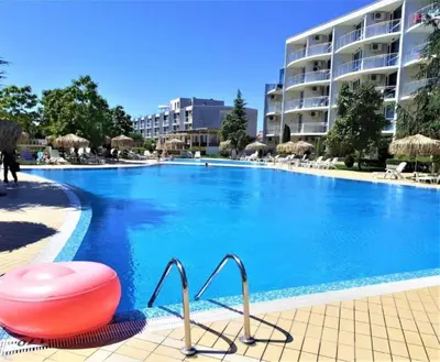 a large swimming pool with a red ball in front of a building at Decor in Atlantis Resort&SPA by RV Apartments in Burgas City