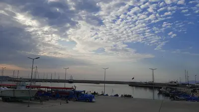 a marina with boats and a bridge with wind turbines at Decor in Atlantis Resort&SPA by RV Apartments in Burgas City