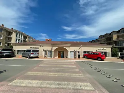 a building with two cars parked in a parking lot at Provence Deluxe Apartment in Atia Resort in Chernomorets